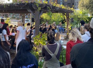 A band plays music in the Forge Garden surrounded by a crowd of students watching